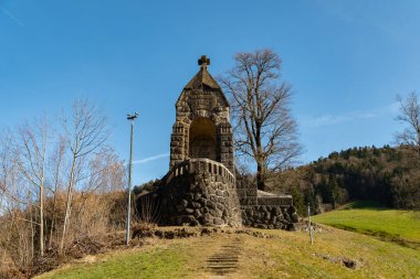 Oberaegeri, İsviçre, 20 Şubat 2023 Güneşli bir günde küçük yeşil bir tepedeki tarihi Morgarten anıtı