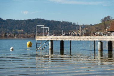 Oberaegeri, İsviçre, 20 Şubat 2023 Güneşli bir günde Aegerisee Gölü 'nün kıyısında küçük bir rıhtım.