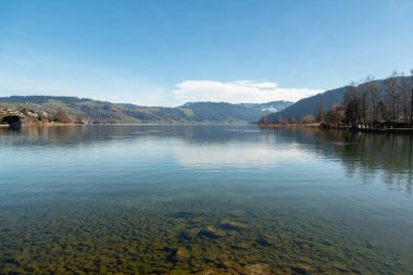 Unteraegeri, İsviçre, 20 Şubat 2023 güneşli bir günde Aegerisee Gölü 'nün rıhtımındaki Idyllic manzara