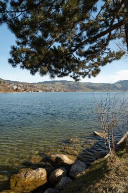 Unteraegeri, İsviçre, 20 Şubat 2023 güneşli bir günde Aegerisee Gölü 'nün rıhtımındaki Idyllic manzara