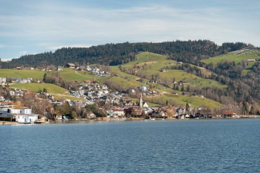 Unteraegeri, İsviçre, 20 Şubat 2023 güneşli bir günde Aegerisee Gölü 'nün rıhtımındaki Idyllic manzara