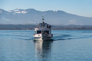 Oberhofen, Canton Bern, İsviçre, 12 Şubat 2023. Küçük tekne, turistleri güneşli bir günde Thun Gölü 'ne götürüyor.