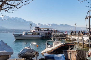 Oberhofen, Canton Bern, İsviçre, 12 Şubat 2023. Küçük tekne, turistleri güneşli bir günde Thun Gölü 'ne götürüyor.