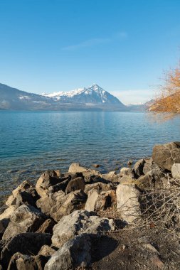 Beatenberg, Canton Bern, İsviçre, 12 Şubat 2023 Thun Gölü ve güneşli bir günde arka planda Niesen Dağı 'nın büyüleyici manzarası