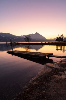 Görünmez, Canton Bern, İsviçre, 12 Şubat 2023. Thun Gölü kıyısından gün batımından hemen sonra fantastik alp manzarası. Arka planda Niesen Dağı.