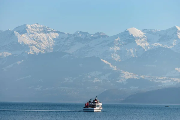 stock image Thun, Switzerland, February 12, 2023 Fantastic view over the snow covered alps from the Schadau park at the lake of Thun