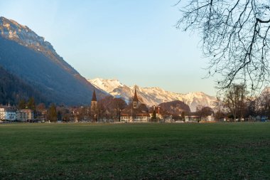 Interlaken, İsviçre, 10 Şubat 2023 Yeşil bir park ve şehir merkezinde fantastik bir dağ manzarası