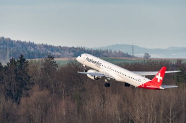 Zürih, İsviçre, 2 Ocak 2023 Helvetic Havayolları Embraer E195-E2 uçağı 28 numaralı pistten kalkıyor.