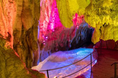 Baar, İsviçre, 29 Nisan 2023 İnanılmaz büyüleyici kaya oluşumu ve Hoellengrotten mağarasında renkli ışıklarla aydınlatılmış küçük bir göl