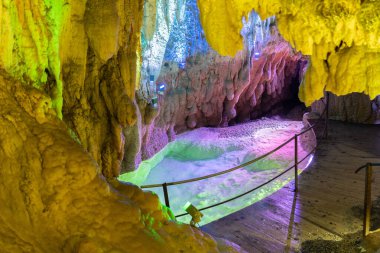 Baar, İsviçre, 29 Nisan 2023 İnanılmaz büyüleyici kaya oluşumu ve Hoellengrotten mağarasında renkli ışıklarla aydınlatılmış küçük bir göl