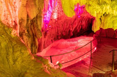 Baar, İsviçre, 29 Nisan 2023 İnanılmaz büyüleyici kaya oluşumu ve Hoellengrotten mağarasında renkli ışıklarla aydınlatılmış küçük bir göl