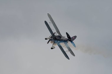 Rhine Vadisi, Saint Gallen, İsviçre, 20 Mayıs, 2023 N-150EK Waco YMF-F5C çift katlı pervaneli uçak, tepenin zirvesinden görülen bir hava gösterisi sırasında sahneleniyor.