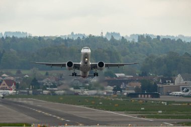 Zürih, İsviçre, 2 Mayıs 2023 HB-AZI Helvetic Havayolları Embraer E195-E2 uçağı 28 numaralı pistten kalkıyor.