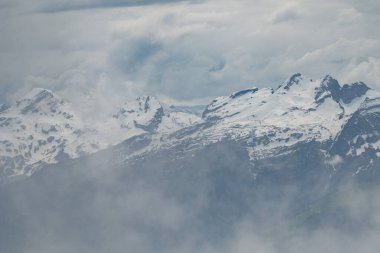 Hoher Dağı Kasten, Saint Gallen, İsviçre, 20 Mayıs 2023 Majestic dağ manzaralı bulutlu bir günde karla kaplı zirveler