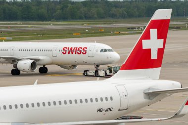 Zürih, İsviçre, 19 Mayıs 2023 HB-IOH İsviçre uluslararası havayolları Airbus A321-111 başka bir İsviçre uçağının arkasında apron boyunca çekildi.