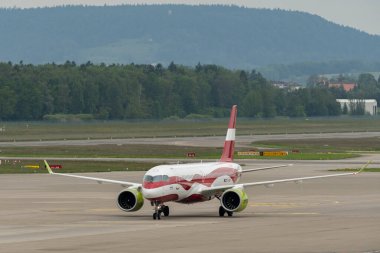 Zürih, İsviçre, 19 Mayıs 2023 YL-ABN Hava Baltık Bombardıman uçağı CS-300 veya Airbus A220 uçakları önlüğün üzerinde uçuyor