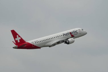 Zürih, İsviçre, 19 Mayıs 2023 HB-JVP Helvetic Airways Embraer E-190LR uçağı 10 numaralı pistten havalandıktan hemen sonra