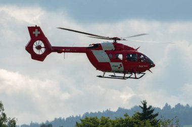 Speck-Fehraltorf, Zürih, İsviçre, 1 Temmuz 2023 İsviçre hava ambulansı REGA helikopter H145 küçük bir havaalanına yaklaşıyor.