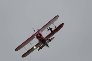 Speck-Fehraltorf, Zürih, İsviçre, 1 Temmuz 2023 N-450D Boeing PT-13D tarihi çift katlı uçak ve bir hava gösterisi sırasında muhteşem bir kanat yürüyüşü performansı sergiliyor.