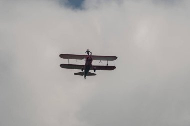 Speck-Fehraltorf, Zürih, İsviçre, 2 Temmuz 2023 N-450D Boeing PT-13D tarihi çift katlı uçak hava gösterisi sırasında kanat yürüyüşü yapan bir kadınla