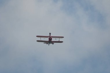 Speck-Fehraltorf, Zürih, İsviçre, 2 Temmuz 2023 N-450D Boeing PT-13D tarihi çift katlı uçak hava gösterisi sırasında kanat yürüyüşü yapan bir kadınla