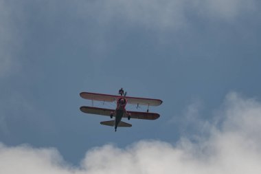 Speck-Fehraltorf, Zürih, İsviçre, 2 Temmuz 2023 N-450D Boeing PT-13D tarihi çift katlı uçak hava gösterisi sırasında kanat yürüyüşü yapan bir kadınla