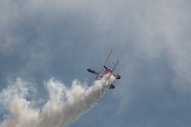 Speck-Fehraltorf, Zürih, İsviçre, 2 Temmuz 2023 N-450D Boeing PT-13D tarihi çift katlı uçak hava gösterisi sırasında kanat yürüyüşü yapan bir kadınla