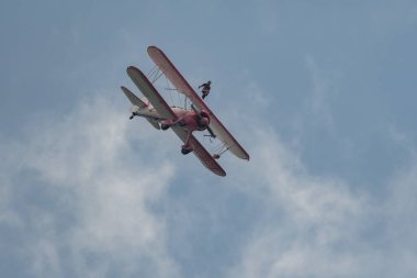 Speck-Fehraltorf, Zürih, İsviçre, 2 Temmuz 2023 N-450D Boeing PT-13D tarihi çift katlı uçak hava gösterisi sırasında kanat yürüyüşü yapan bir kadınla