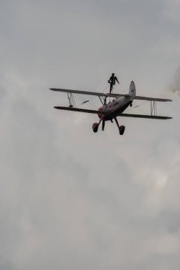 Speck-Fehraltorf, Zürih, İsviçre, 2 Temmuz 2023 N-450D Boeing PT-13D tarihi çift katlı uçak hava gösterisi sırasında kanat yürüyüşü yapan bir kadınla