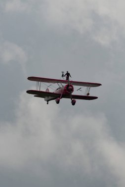 Speck-Fehraltorf, Zürih, İsviçre, 2 Temmuz 2023 N-450D Boeing PT-13D tarihi çift katlı uçak hava gösterisi sırasında kanat yürüyüşü yapan bir kadınla