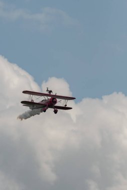 Speck-Fehraltorf, Zürih, İsviçre, 2 Temmuz 2023 N-450D Boeing PT-13D tarihi çift katlı uçak hava gösterisi sırasında kanat yürüyüşü yapan bir kadınla