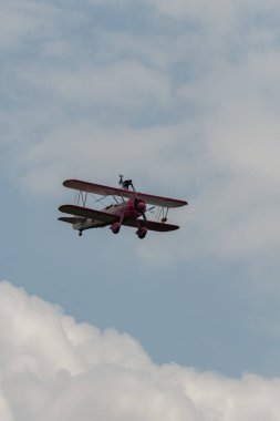 Speck-Fehraltorf, Zürih, İsviçre, 2 Temmuz 2023 N-450D Boeing PT-13D tarihi çift katlı uçak hava gösterisi sırasında kanat yürüyüşü yapan bir kadınla