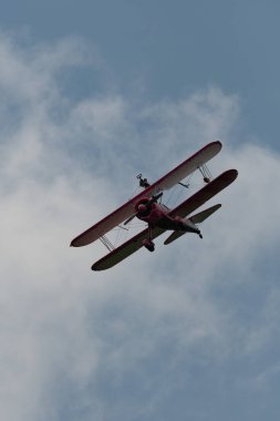 Speck-Fehraltorf, Zürih, İsviçre, 2 Temmuz 2023 N-450D Boeing PT-13D tarihi çift katlı uçak hava gösterisi sırasında kanat yürüyüşü yapan bir kadınla