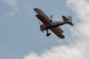 Speck-Fehraltorf, Zürih, İsviçre, 2 Temmuz 2023 N-450D Boeing PT-13D tarihi çift katlı uçak hava gösterisi sırasında kanat yürüyüşü yapan bir kadınla