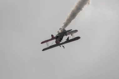 Speck-Fehraltorf, Zürih, İsviçre, 2 Temmuz 2023 N-450D Boeing PT-13D tarihi çift katlı uçak hava gösterisi sırasında kanat yürüyüşü yapan bir kadınla