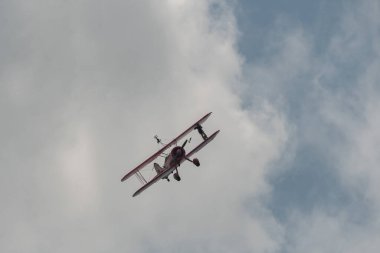 Speck-Fehraltorf, Zürih, İsviçre, 2 Temmuz 2023 N-450D Boeing PT-13D tarihi çift katlı uçak hava gösterisi sırasında kanat yürüyüşü yapan bir kadınla