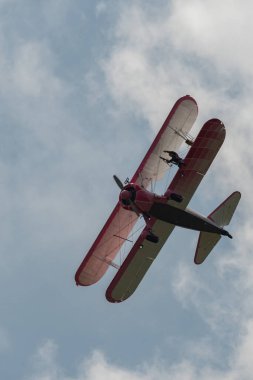 Speck-Fehraltorf, Zürih, İsviçre, 2 Temmuz 2023 N-450D Boeing PT-13D tarihi çift katlı uçak hava gösterisi sırasında kanat yürüyüşü yapan bir kadınla