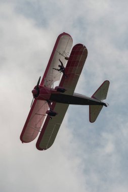 Speck-Fehraltorf, Zürih, İsviçre, 2 Temmuz 2023 N-450D Boeing PT-13D tarihi çift katlı uçak hava gösterisi sırasında kanat yürüyüşü yapan bir kadınla