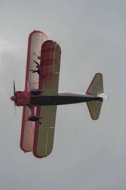 Speck-Fehraltorf, Zürih, İsviçre, 2 Temmuz 2023 N-450D Boeing PT-13D tarihi çift katlı uçak hava gösterisi sırasında kanat yürüyüşü yapan bir kadınla