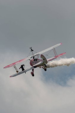 Speck-Fehraltorf, Zürih, İsviçre, 2 Temmuz 2023 N-450D Boeing PT-13D tarihi çift katlı uçak hava gösterisi sırasında kanat yürüyüşü yapan bir kadınla