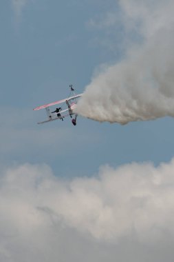 Speck-Fehraltorf, Zürih, İsviçre, 2 Temmuz 2023 N-450D Boeing PT-13D tarihi çift katlı uçak hava gösterisi sırasında kanat yürüyüşü yapan bir kadınla