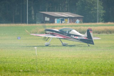 Speck-Fehraltorf, Zürih, İsviçre, 2 Temmuz 2023 HB-MAD Xtreme Air XA-42 Akrobatik uçak çimen pistinde küçük bir havaalanında