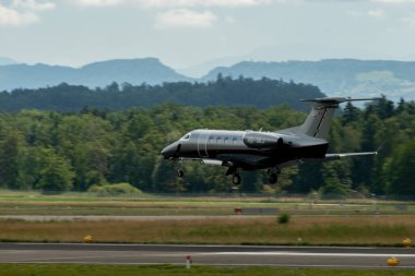 Zürih, İsviçre, 13 Temmuz 2023 HB-VAJ Embraer Fenomen 300E uçağı 14 numaralı piste iniyor.