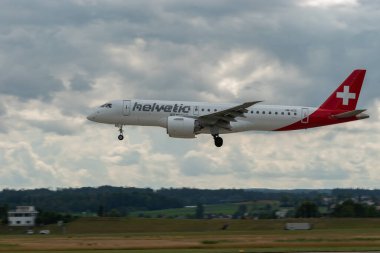Zürih, İsviçre, 13 Temmuz 2023 HB-AZC Helvetic Havayolu Embraer E190-E2 uçağı 14 numaralı piste iniyor.