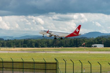 Zürih, İsviçre, 13 Temmuz 2023 HB-JVP Helvetic Airways Embraer E190-LR uçağı 14 numaralı piste iniyor.