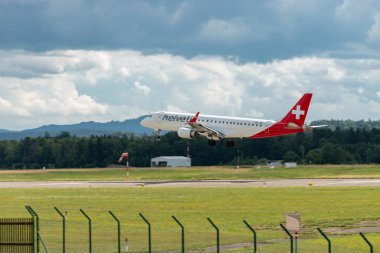 Zürih, İsviçre, 13 Temmuz 2023 HB-JVM Helvetic Airways Embraer E190-LR uçağı 14 numaralı piste iniyor.