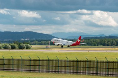 Zürih, İsviçre, 13 Temmuz 2023 HB-JVM Helvetic Airways Embraer E190-LR uçağı 14 numaralı piste iniyor.