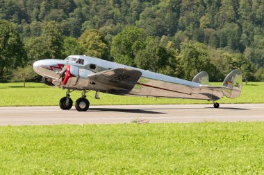 Mollis, İsviçre, 18 Ağustos 2023 NC-18125 Lockheed Model 12 Electra Junior uçağı piste iniyor.