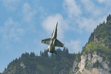 Mollis, İsviçre, 18 Ağustos 2023 İsviçre ordusu McDonnell Douglas F / A-18 Hornet jeti hava gösterisi sırasında akrobasi yapıyor.