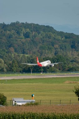 Zürih, İsviçre, 6 Eylül 2023 HB-AZB Helvetic Havayolları Embraer E190-E2 uçağı 14 numaralı piste iniyor.